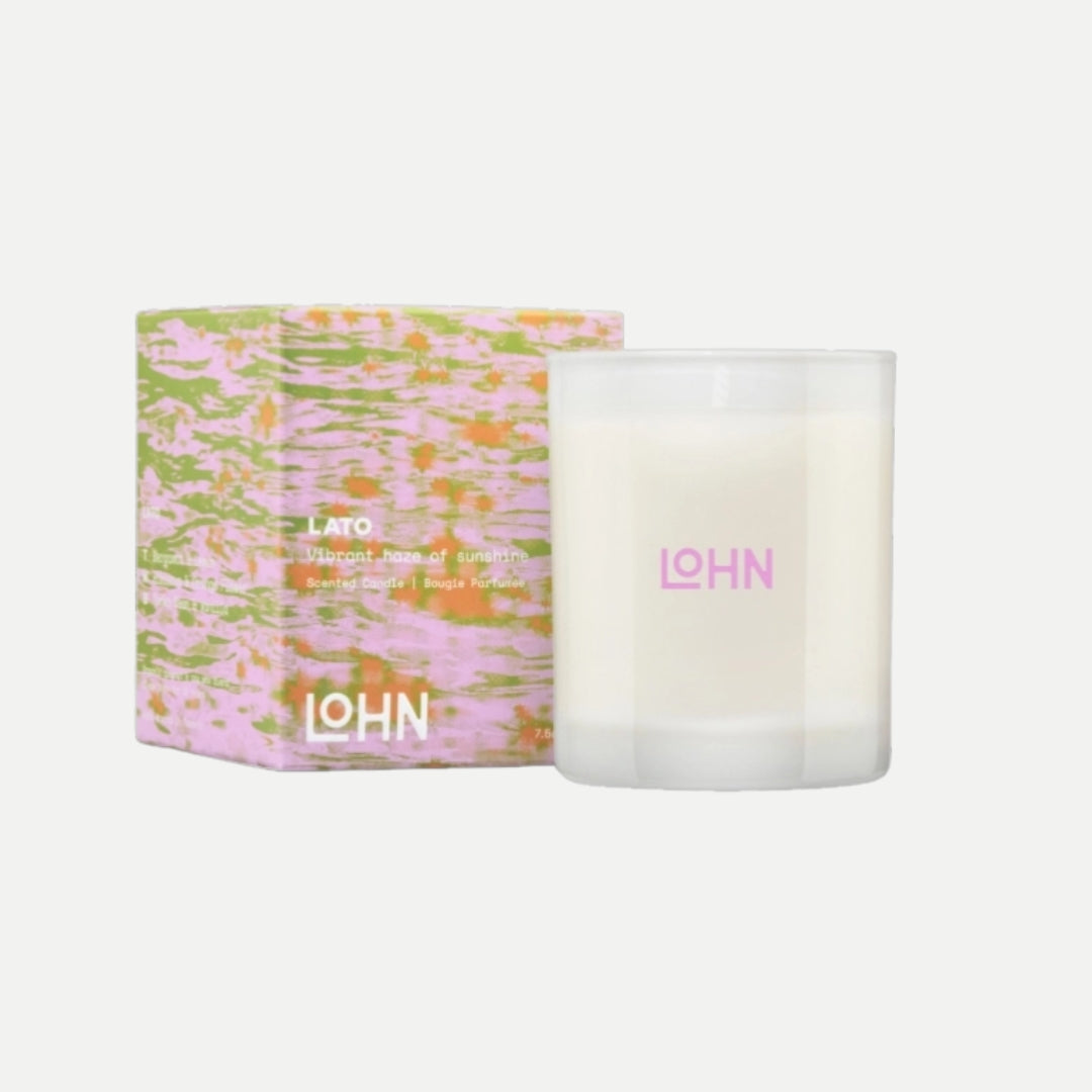 Candle with floral packaging and 'LOHN' branding on a white background