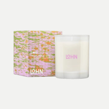 Candle with floral packaging and 'LOHN' branding on a white background
